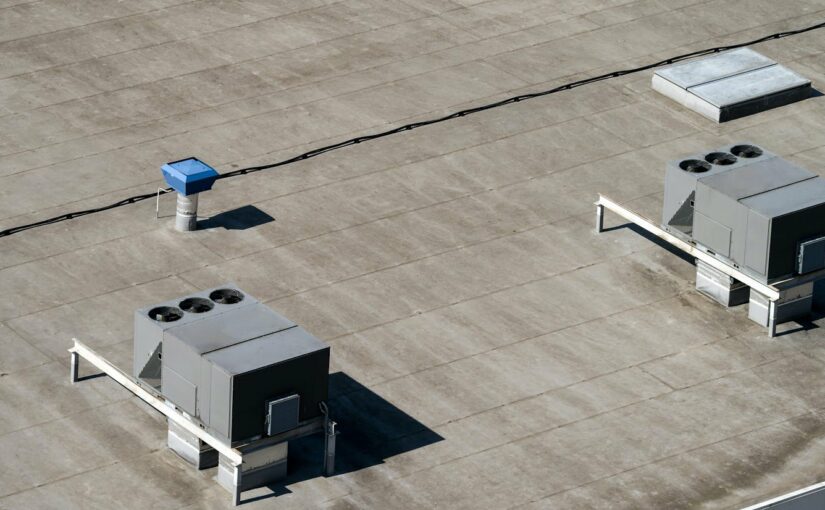 The external units of the commercial air conditioning and ventilation systems are installed on the roof of an industrial building.