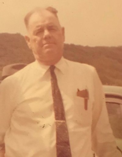 Older man in white shirt and burgundy tie standing outdoors, founder of roofing and home improvement company in Greenville, South Carolina